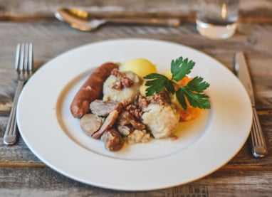 Raspeballe med saltkjøtt, pølse, kålrabistappe og baconfett.
