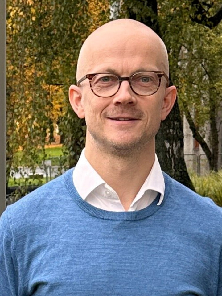 To personer foran NHOs logo ved Næringslivets Hus