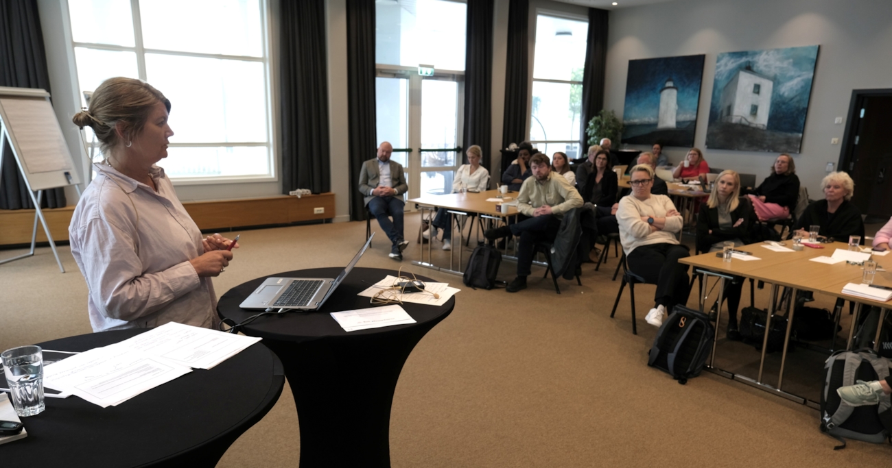 Foredragsholder med publikum bak