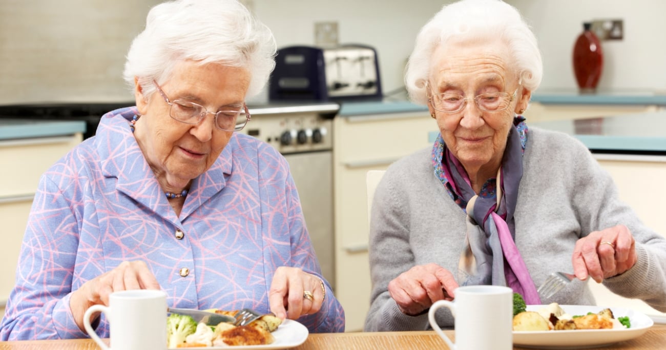 To eldre kvinner spiser middag
