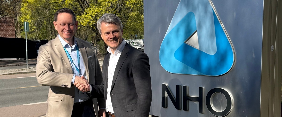 Håndslag ved siden av NHO slogo