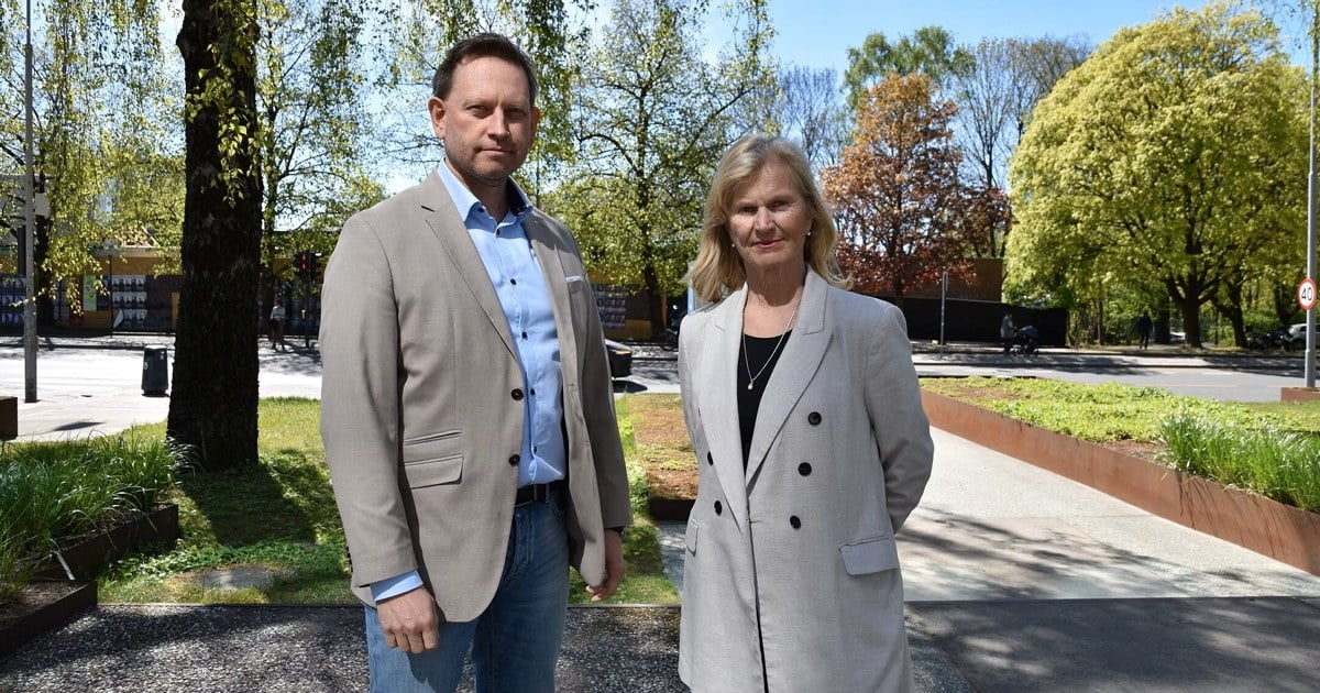 to direktører ved siden av skilt